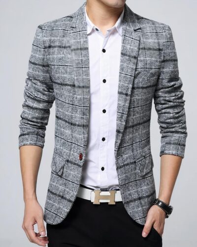 Un homme porte une veste grise à carreaux avec une chemise blanche et un pantalon noir