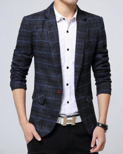 Un homme porte un blazer à carreaux bleu, une chemise blanche et un pantalon noir