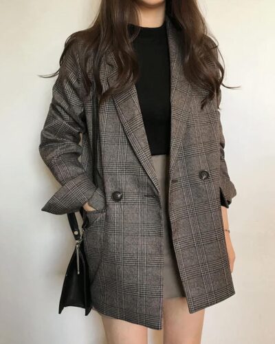 Femme portant un blazer à carreaux.