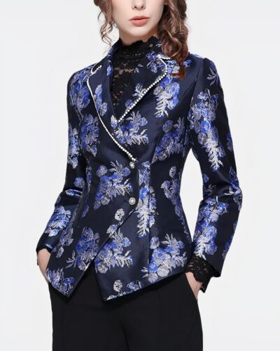 Femme portant un blazer avec des fleurs bleues sur fond gris.
