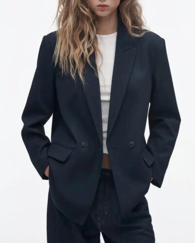 Blazer bleu marine porté par une femme en tee shirt et pantalon sombre