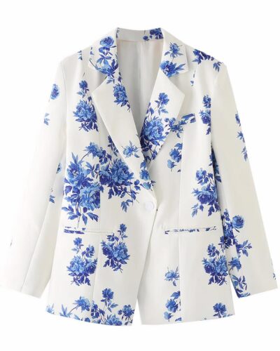 Blazer blanc à fleurs bleues sur fond blanc.