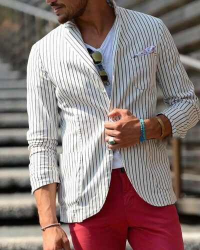 Homme portant un blazer blanc à rayures et un pantalon rouge.