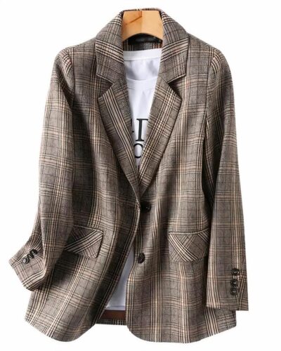 Blazer gris à carreaux sur un cintre sur fond blanc.