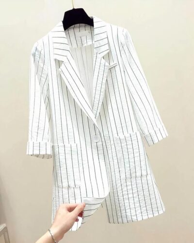 Blazer blanc rayé sur un cintre.