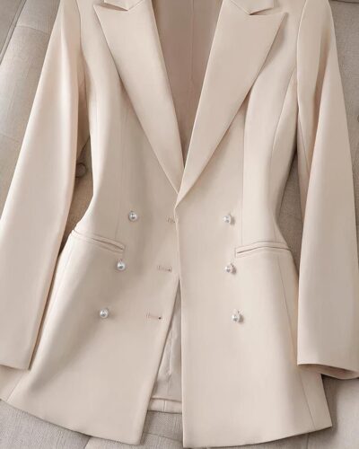 Blazer beige posé sur un canapé beige