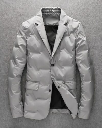 Photo d'un blazer matelassé gris pour homme à deux boutons et rabats de poches, col cranté et doublure intégrale noire sur un fond gris foncé