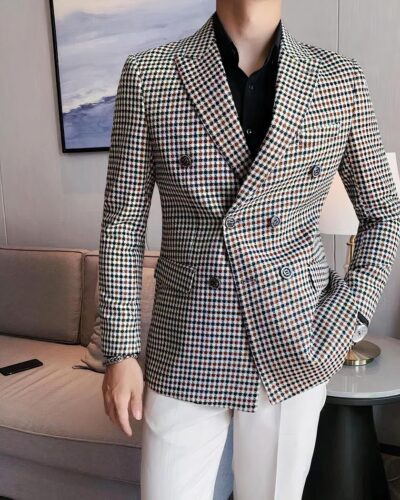 Un homme porte un blazer à carreaux avec un pantalon blanc et une chemise noire