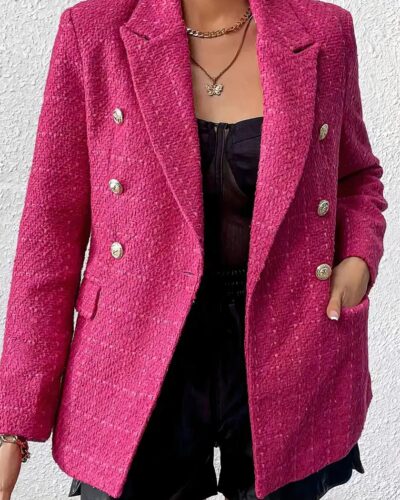 Femme portant un blazer rose sur un fond blanc.