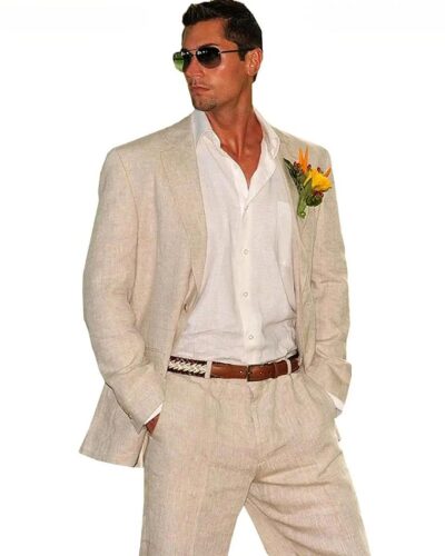Photo d'un homme debout portant un ensemble blazer beige en lin avec une ceinture marron et beige et une chemise blanche, des lunettes de soleil et un petit bouquet de fleurs à la boutonnière
