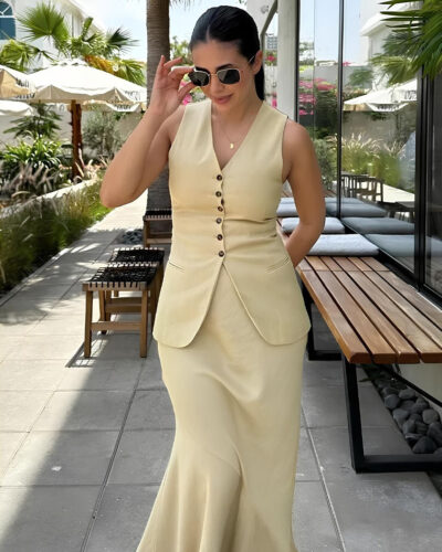 Femme brune portant un ensemble blazer femme gilet et jupe longue sur une terrasse