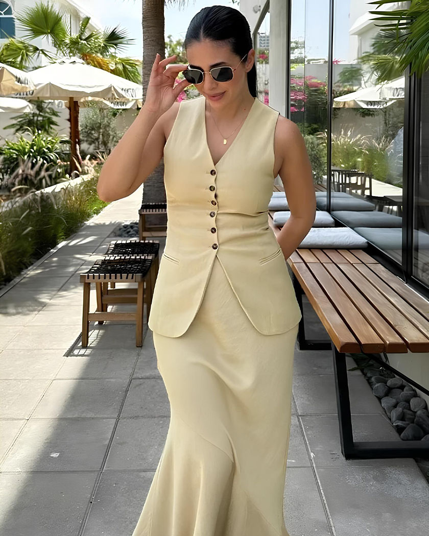 Ensemble blazer femme gilet et jupe longue Femme brune portant un ensemble blazer femme gilet et jupe longue sur une terrasse